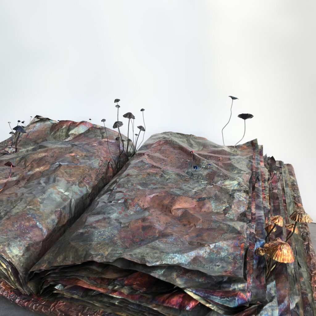 Book of Alchemical Secrets resting open, its multi-coloured copper surface covered in sprouting copper mushrooms
