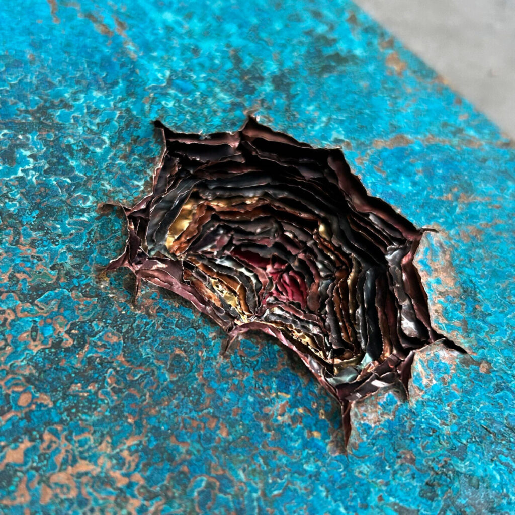 Detail of the wound in Dangerous Knowledge, revealing layer upon layer of multicoloured copper beneath the turquoise surface