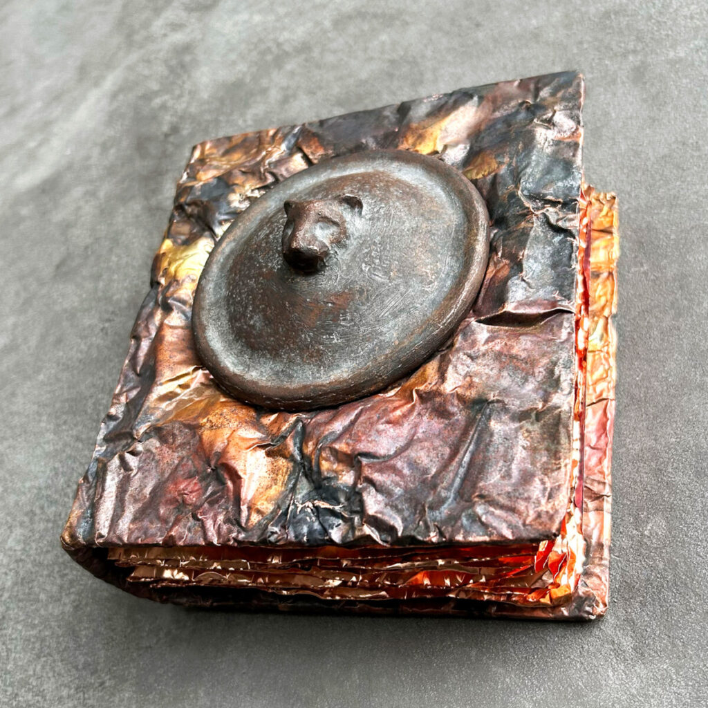 Felines and Other Magical Creatures, a patinated copper artist's book with a round cast-bronze medallion set into the cover