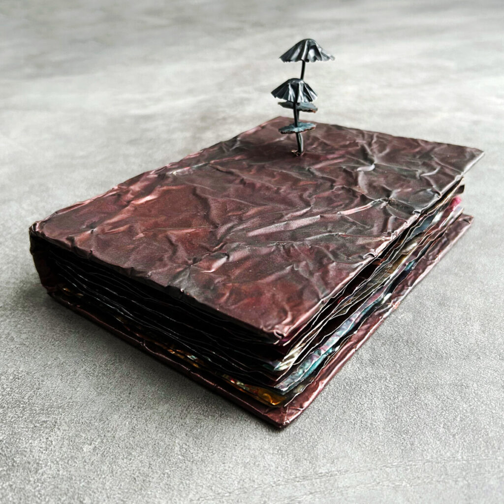 PhD Thesis: How to Manage Mushrooms, a patinated copper artist's book with a marbled red-brown cover with copper mushrooms growing through the cover, shown closed