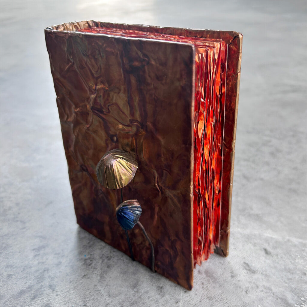 Nature Guide for Adventurers shown closed and upright, a patinated copper book topped with a copper mushroom