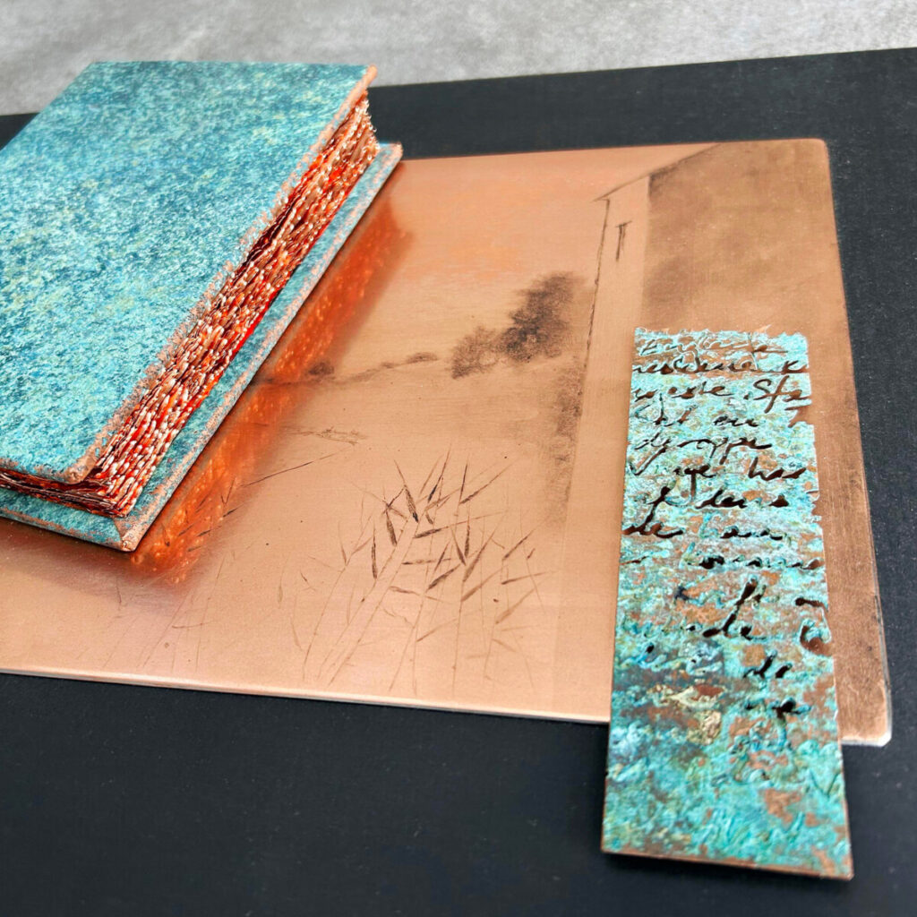 Travel Diary of a Poet on a black surface, showing the drypoint plate, turquoise patina and etched, patinated text