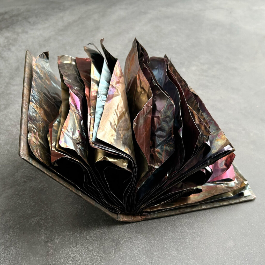 The Unstoppable Story open, its wild multi-coloured copper pages spilling loose